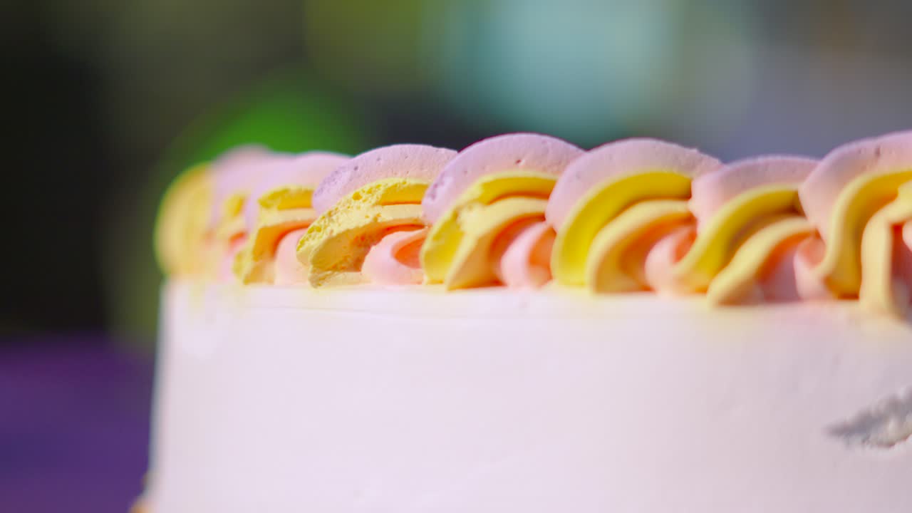Side View of Colorful Icing with Cream Frosting on Delicious Birthday Celebration Dessert Cake with Shallow DOF.
