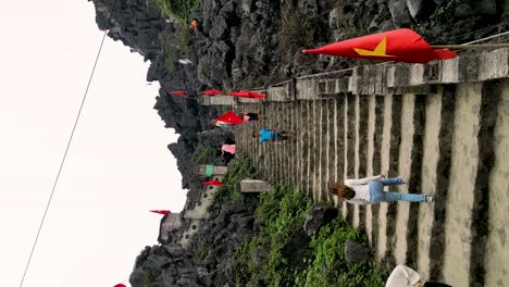 vertical aerial shot of tourists climbing to the hang mua mountain viewpoint