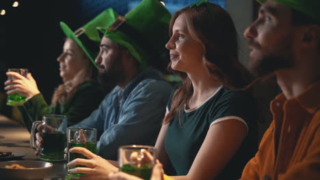 amigos assistindo tv em um pub e bebendo cerveja