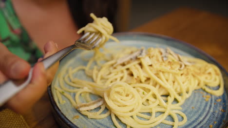 details of a woman eating a spaghetti dish at the resort during dinner