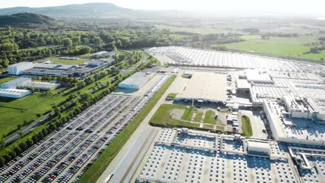 aerial shot of a car factory producing automobiles in the sunset near the industrial district