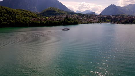 aerial take of the thunensee lake in swiss alps, nearby interlaken town