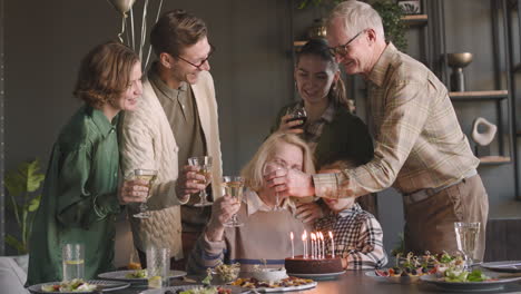 ältere frau, die ihren geburtstag mit ihrer familie zu hause feiert