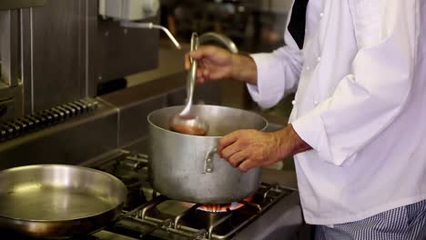 handsome chef stirring a large pot