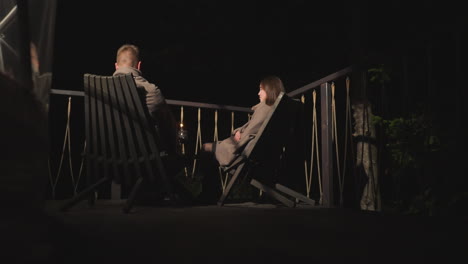 romantic couple sitting on a deck at night