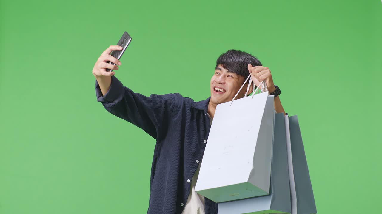 쇼핑 가방 을 들고 셀피 를 찍는 남자