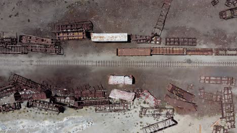 aerial looks directly down onto old railroad train graveyard, bolivia