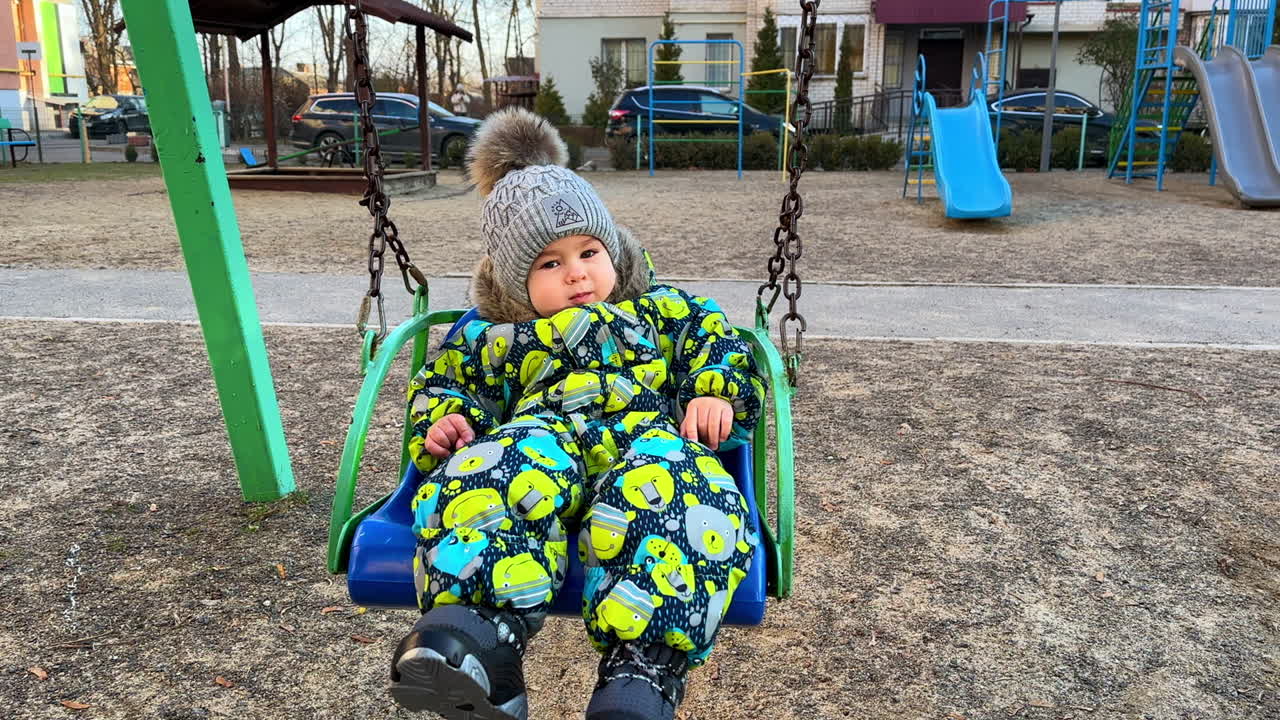 Baby in a swing at the playground in winter