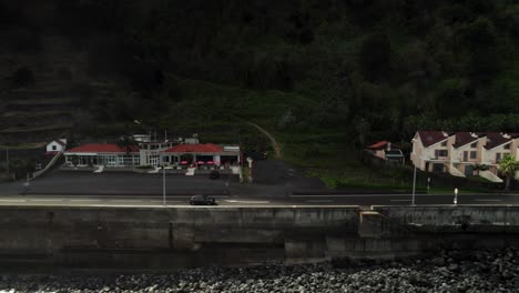 Drone-Shot-of-Black-Car-Driving-Straight-Road-in-front-of-the-Mountain