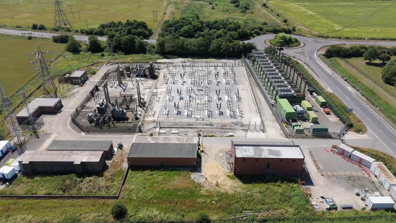 Cinematic aerial drone view of Immingham substation with transformers and pylons for electricity transmission in England UK Europe