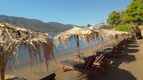 sunbeds with dried grass in paralia mikro neorio with blue colour water bay