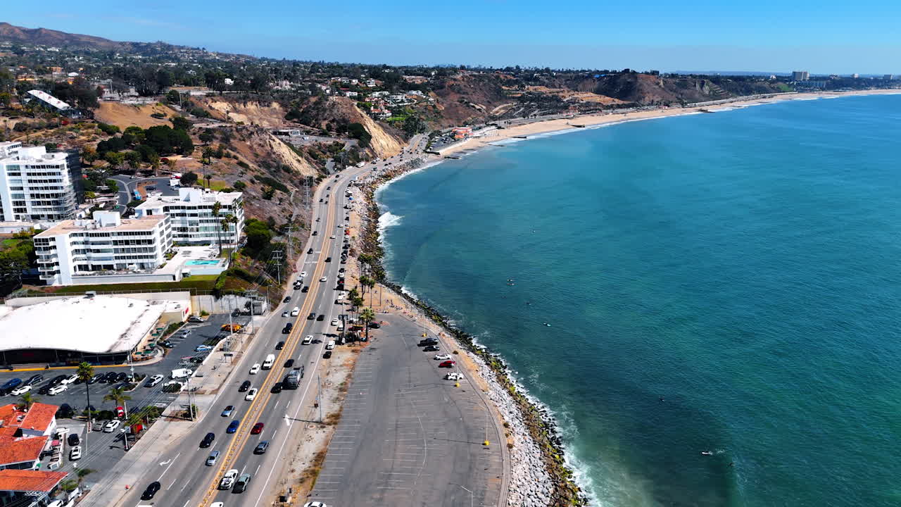 Hectic traffic on the road along the Pacific Ocean coast. View on the rocky landscape of Malibu, California, USA