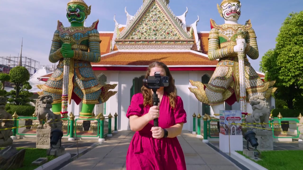 Turista feminina segurando um celular com gimbal no Templo Budista Wat Arun em Bangkok, Tailândia. Plano de revelação.