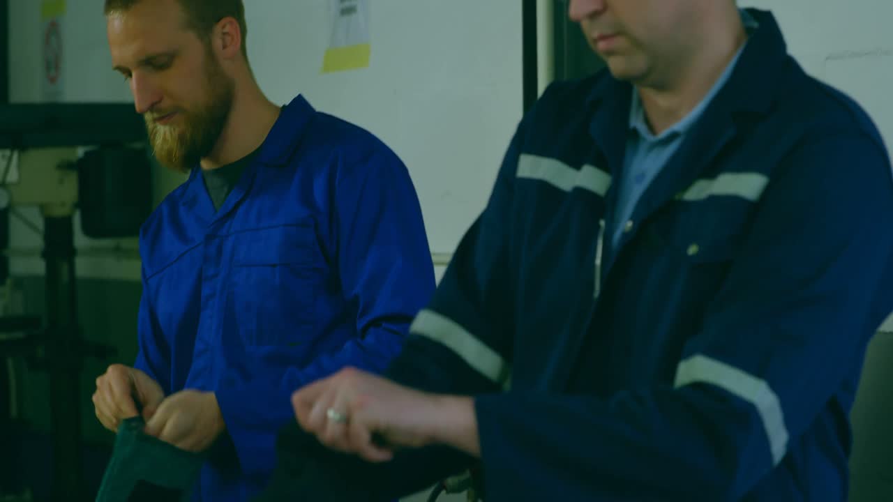 Ingegneri della robotica che indossano indumenti protettivi in magazzino 4k