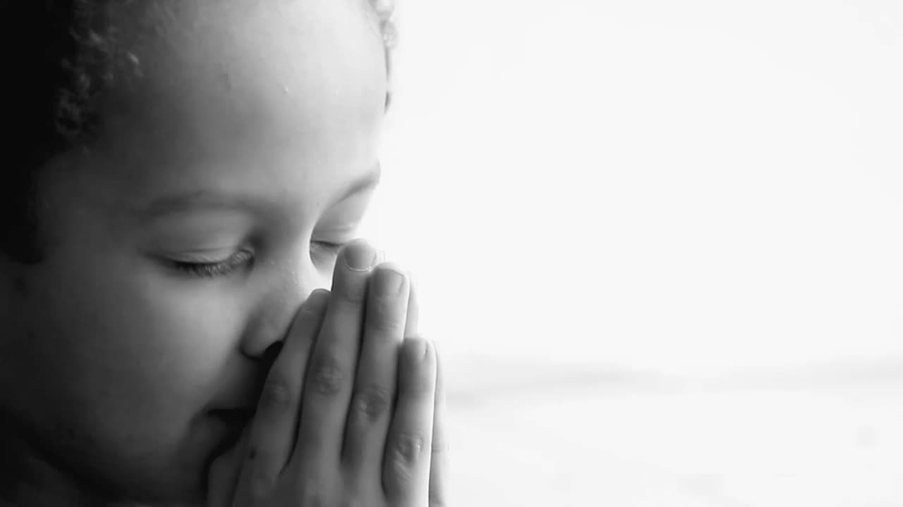 boy praying to God with hands held together with people sock footage stock video