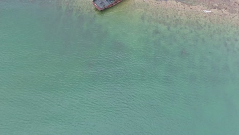 Top-down-aerial-shot-of-shipwreck-at-coastline