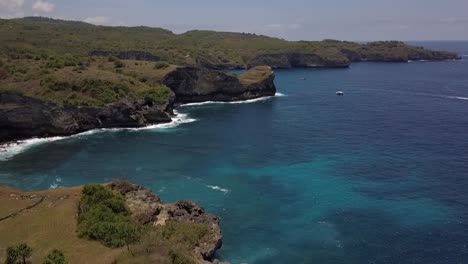 increíble vuelo con vista aérea que se hunde lentamente con un dron disparado frente a un puente natural roto en la playa de bali