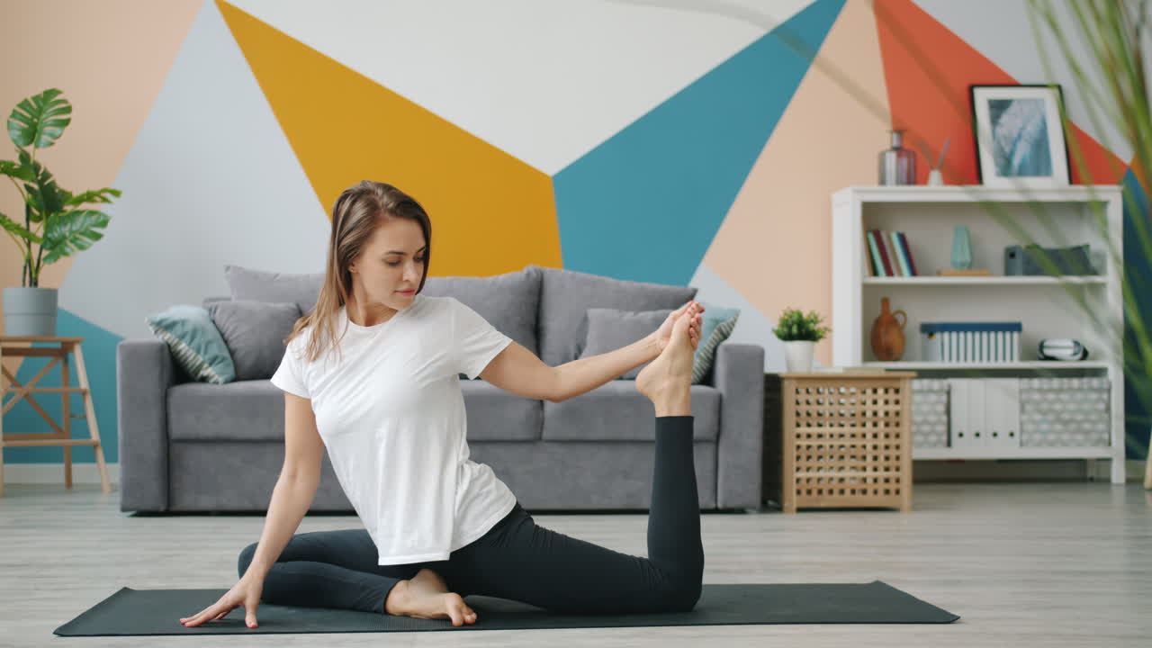Woman practicing seated yoga pose in a living room