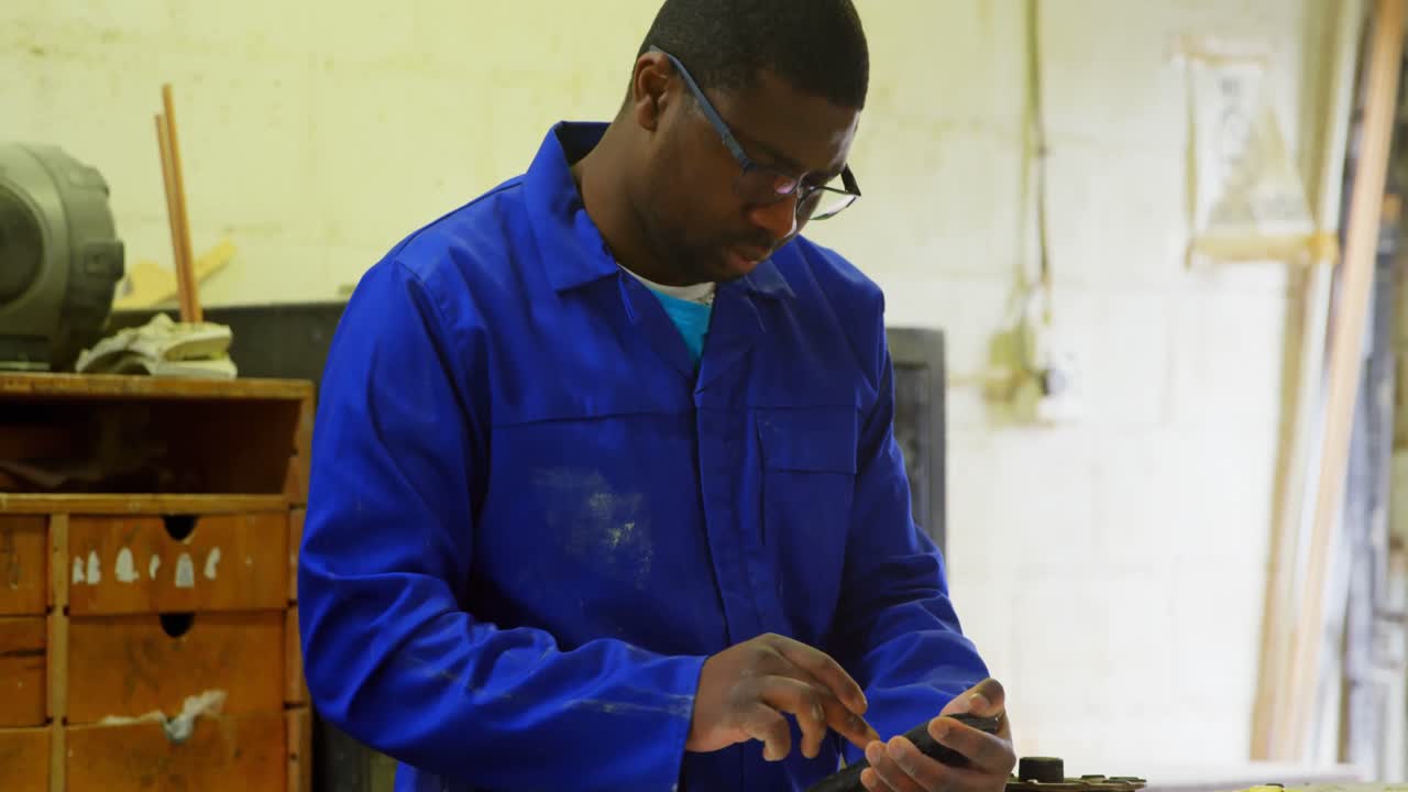 Worker working at table in foundry workshop 4k