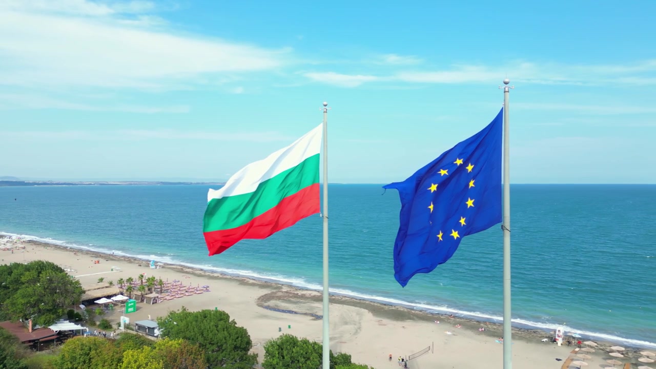 Al rallentatore, il drone riprende le bandiere bulgara e dell'Unione Europea che sventolano sopra la costa di Burgas, Bulgaria, in una tranquilla giornata estiva