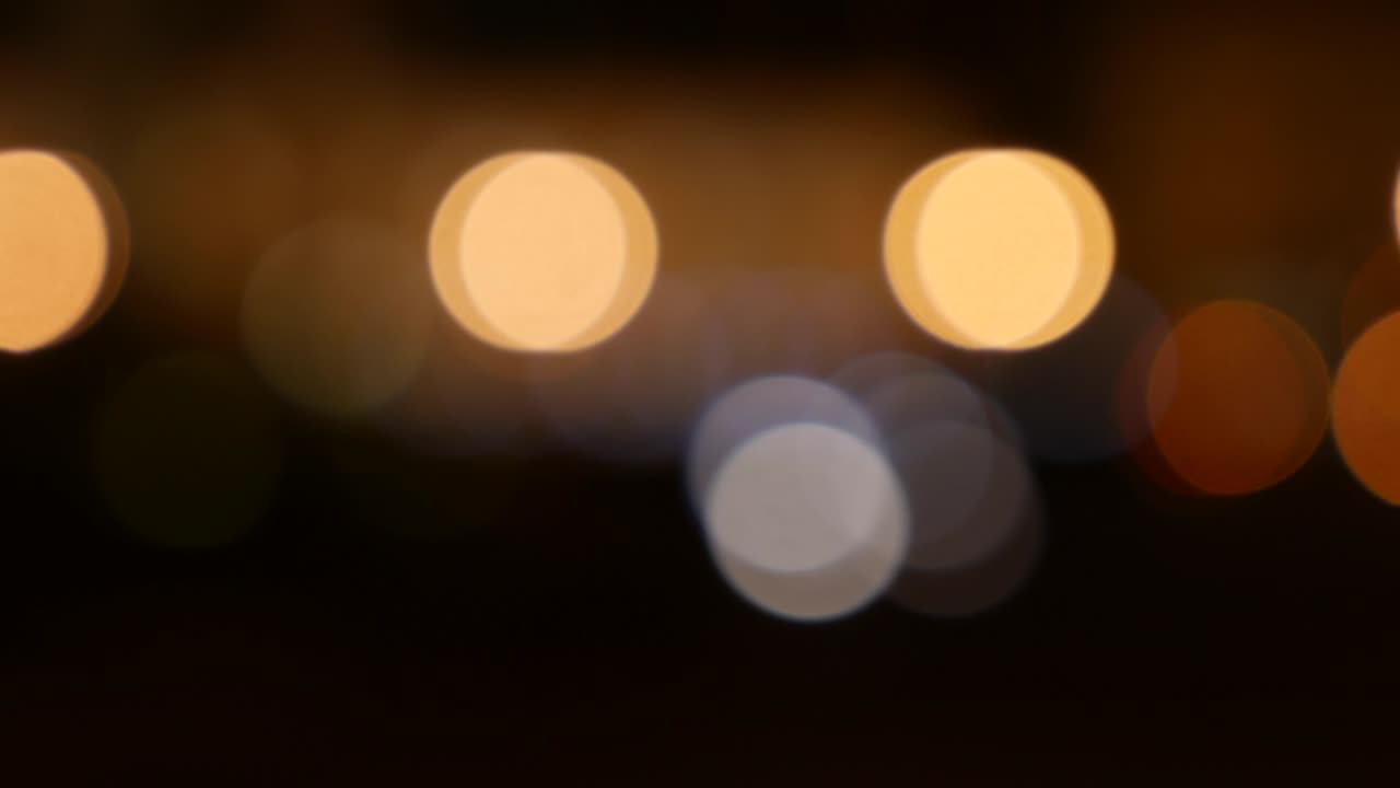 hermoso bokeh brillante en el fondo oscuro borroso por la noche. el redondo bokeh colorido brilla de las luces de los coches en la calle de la ciudad. fuera de foco con borroso. luces de la ciudad sin enfoque. bokeh de tráfico. concepto abstracto