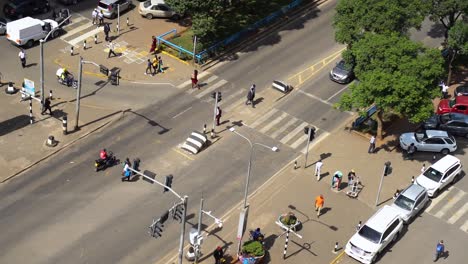 Birds-eye-view-of-pedestrians-crossing-the-road-during-traffic-in-Kenya,-Nairobi