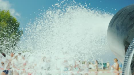 the gun fires the streams of foam on the crowd of tourists. foam party on the beach