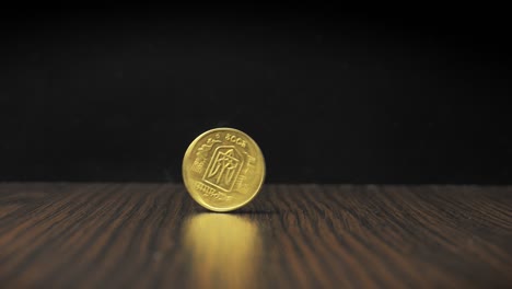 la moneda de oro gira sobre la mesa y se ralentiza gradualmente, simboliza la fluctuación de los mercados financieros la caída y el aumento de los precios, la inversión de capital en oro, el comercio de negocios en el mercado de valores