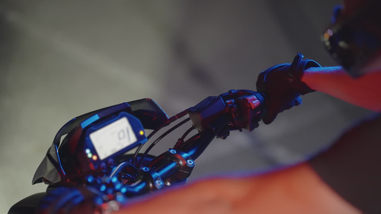 모터사이클 운전자는 낮은 조명 조건에서 손잡이를 작동합니다.