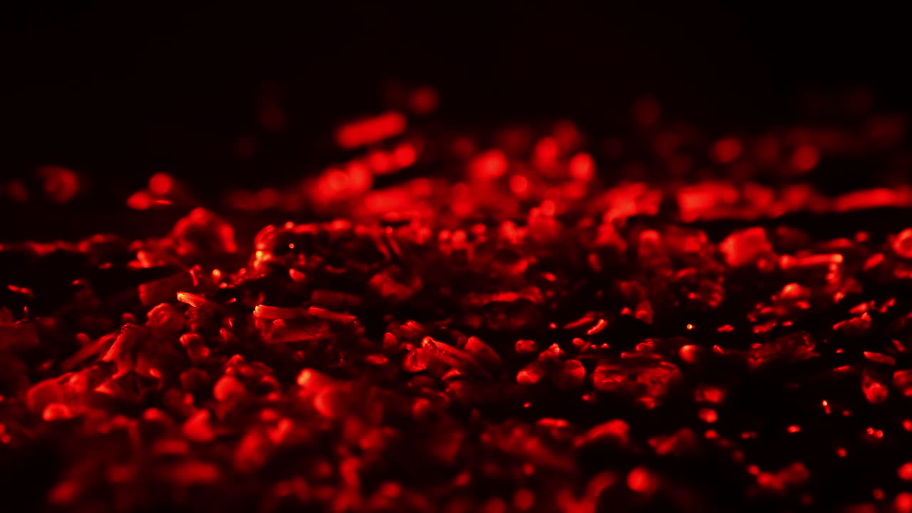 Wood in the campfire burnt out and charcoal is still hot. Red charcoal glowing. Close up.
