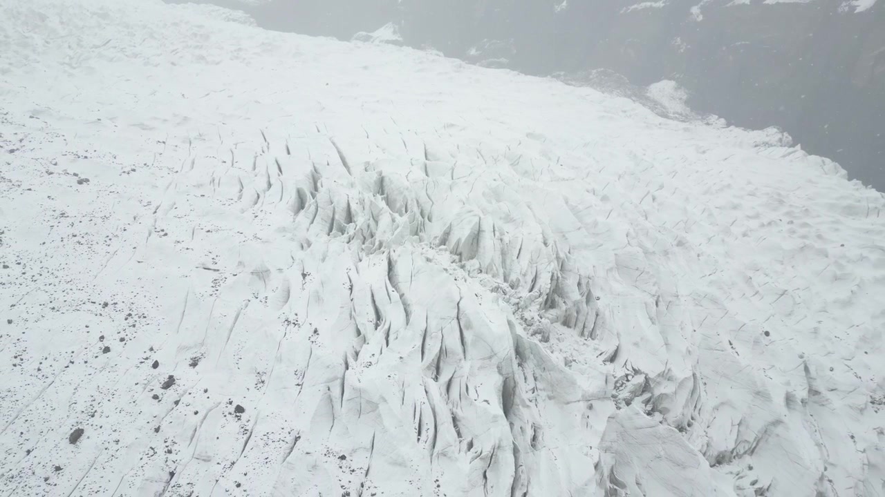 Vista aérea sobre os vastos campos de gelo branco profundamente fendidos da Geleira Passu Cones no Vale de Hunza, Paquistão, filmagem de drone com afastamento da natureza asiática