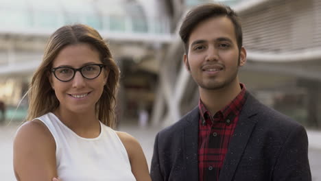 Cheerful-young-business-people-smiling-at-camera-on-street