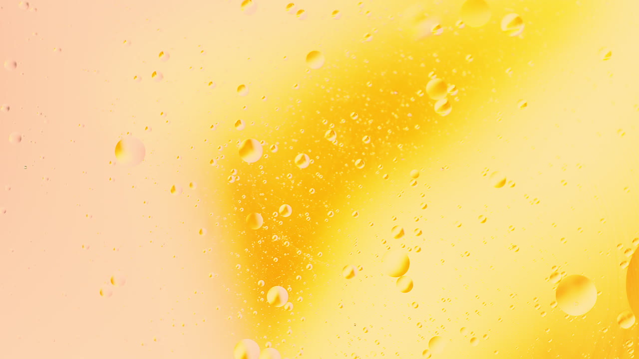 Primo piano ravvicinato di bolle d'olio in rotazione nell'acqua con sfondo astratto di miscelazione a gradiente di colore