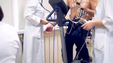 heart diagnosis device on a patient. doctor test patient vital parameters using attached electrodes on patient's chest.