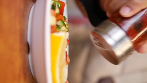 seasoning a fresh salad with spices