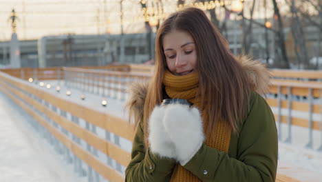 woman enjoying a warm drink at an ice rink