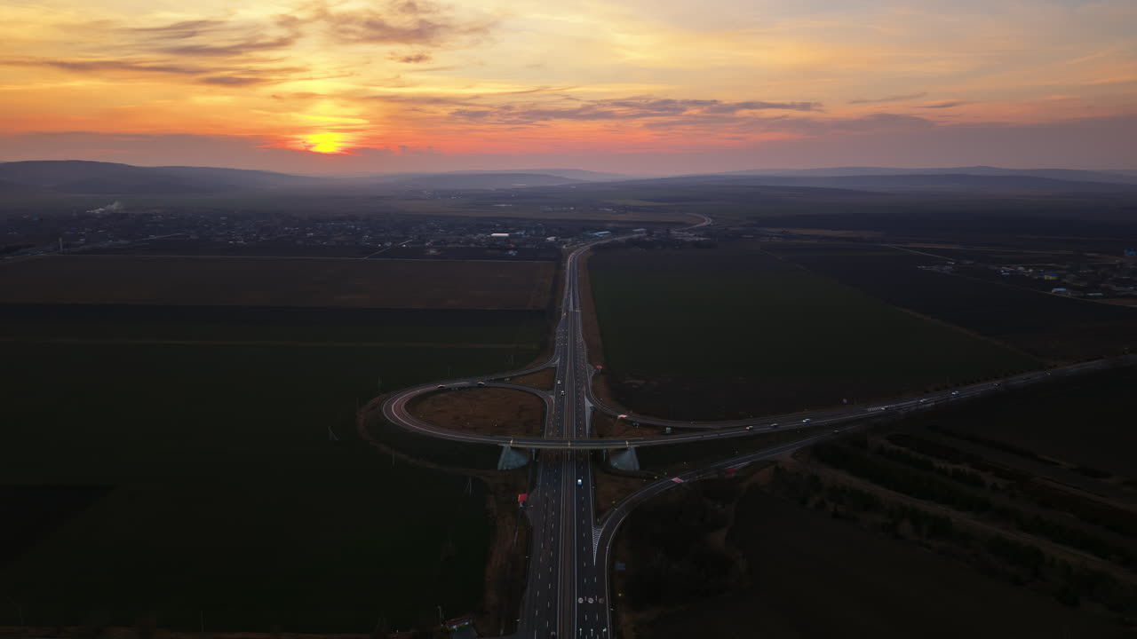 Aerial drone view of cars driving on the highway in Moldova at sunset time lapse