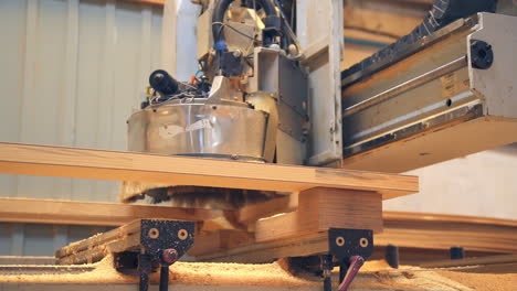 machine tool moves along the door billet. chipping out the parts for future wooden door. low angle view.