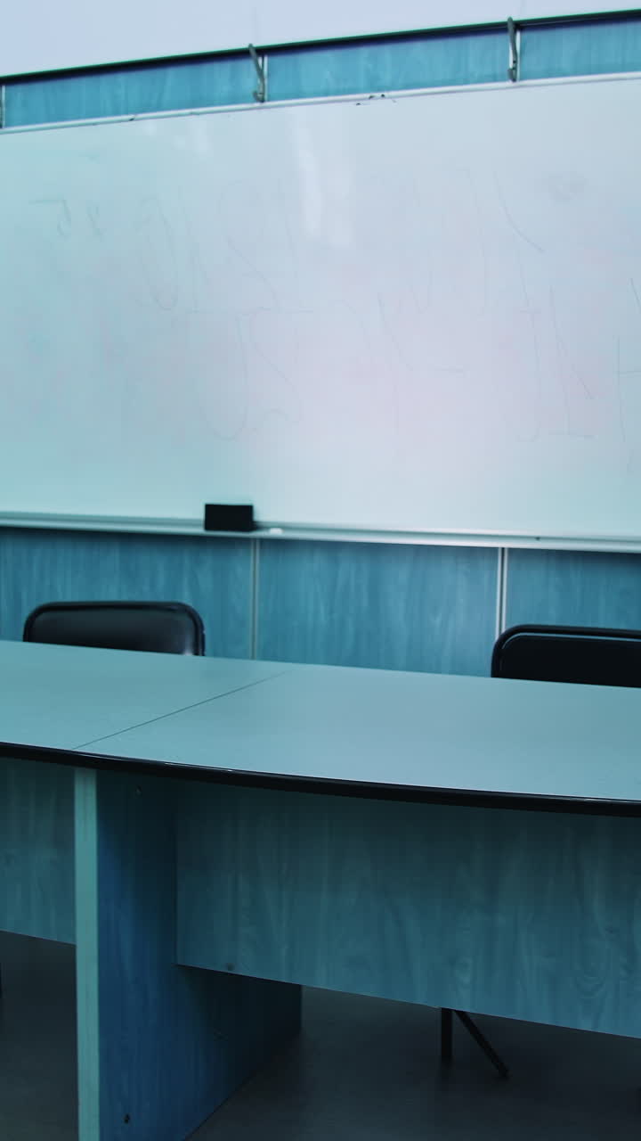 Presidium place with modern equipment. Auditorium with a blackboard, white board and teacher's table. Beautiful empty classroom in blue colors. Vertical video