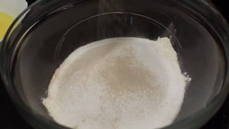 yeast being added on top of flour in mixing bowl