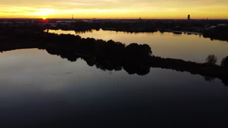 Silhouetten-Von-Bäumen-Und-Wasser-Während-Des-Goldenen-Sonnenuntergangs-Von-Hoch-Oben