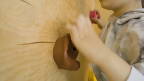 Nahaufnahme-Eines-Jungen-Mädchens,-Das-Eine-Indoor-Kletterwand-Klettert