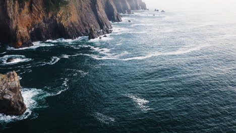 flight along coastline of oregon, rugged cliffs descending into pacific ocean