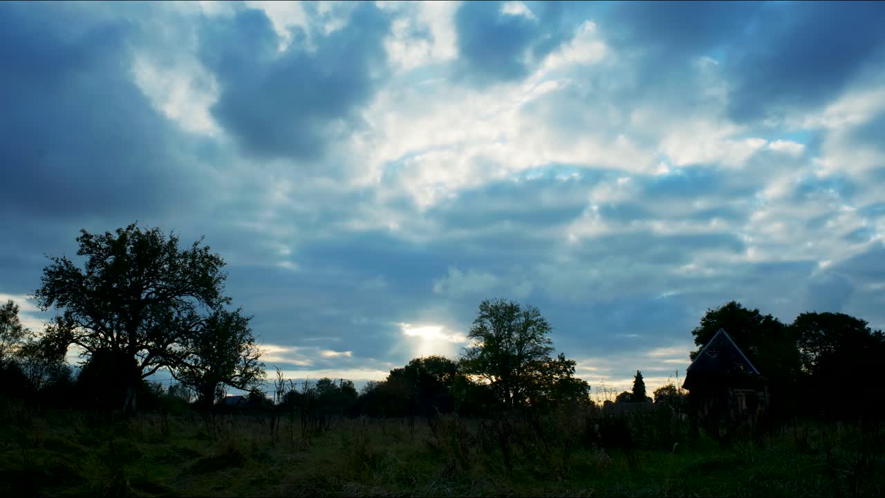 Timelapse 4K di un campo in una sera assolata con un tramonto nuvoloso.