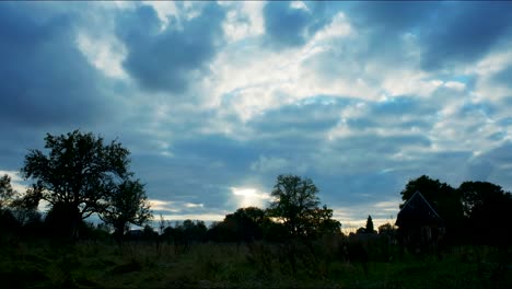 4k-Zeitraffer-Eines-Feldes-An-Einem-Sonnigen-Abend-Mit-Bewölktem-Sonnenuntergang