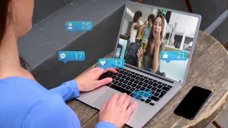 Animación-De-Iconos-De-Medios-Sobre-Una-Mujer-Caucásica-Que-Tiene-Una-Videollamada-Portátil-Con-Diversos-Amigos