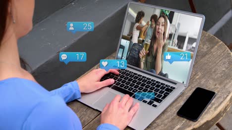 animación de iconos de los medios de comunicación sobre una mujer caucásica que tiene una videollamada portátil con diversos amigos