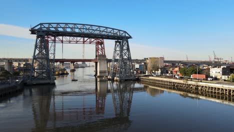 Aerial-Pan-Puente-Transbordador-And-Small-Boat-On-River,-Buenos-Aires