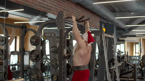 ambicioso hombre santa haciendo ejercicio en el gimnasio. deportista haciendo dominadas