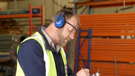 trabajador escribiendo en el clipboard en la industria de fabricación de cuerdas 4k